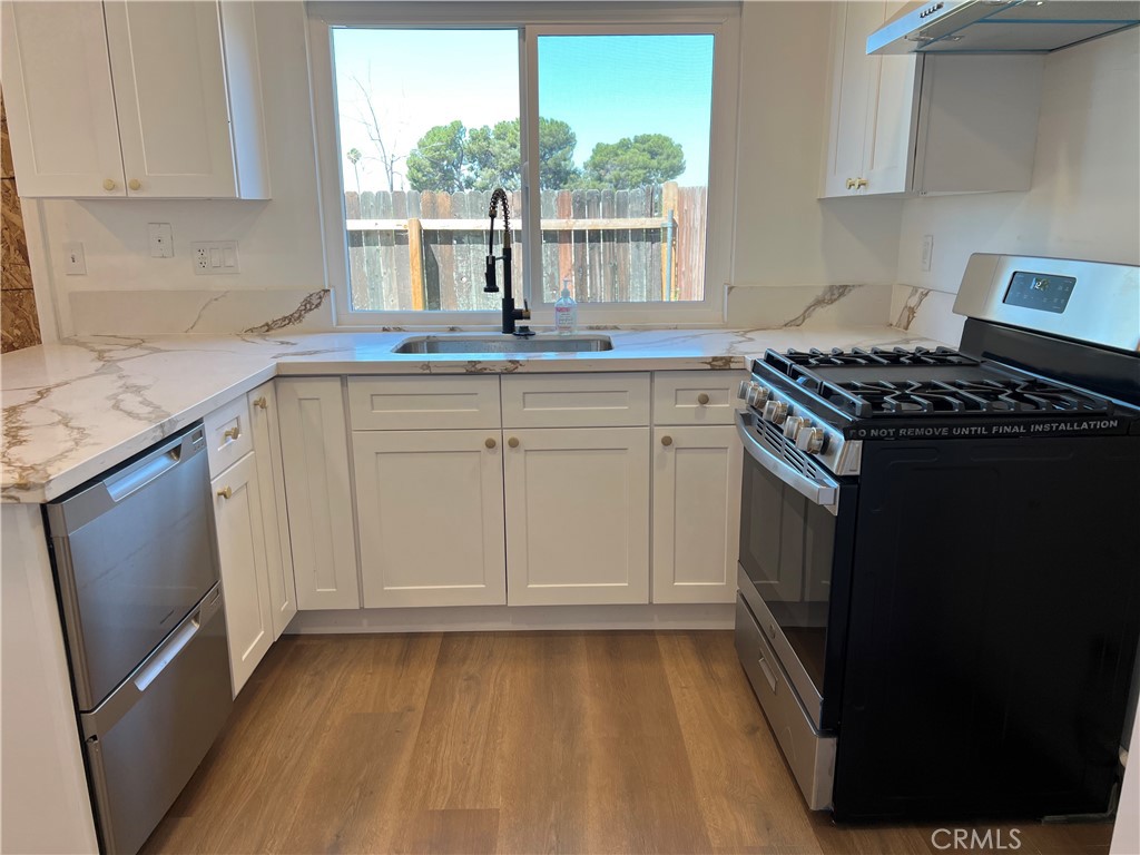 a kitchen with granite countertop a sink stove and cabinets