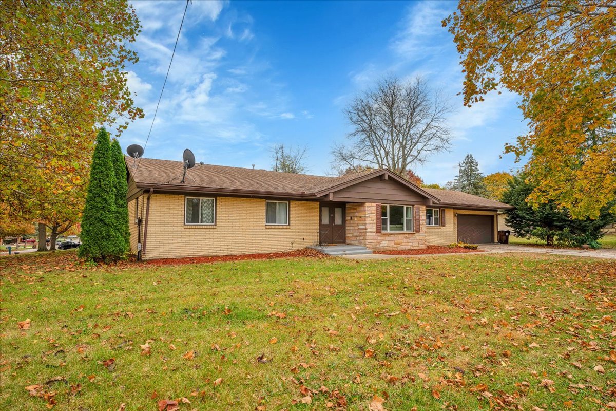 a front view of a house with yard and trees