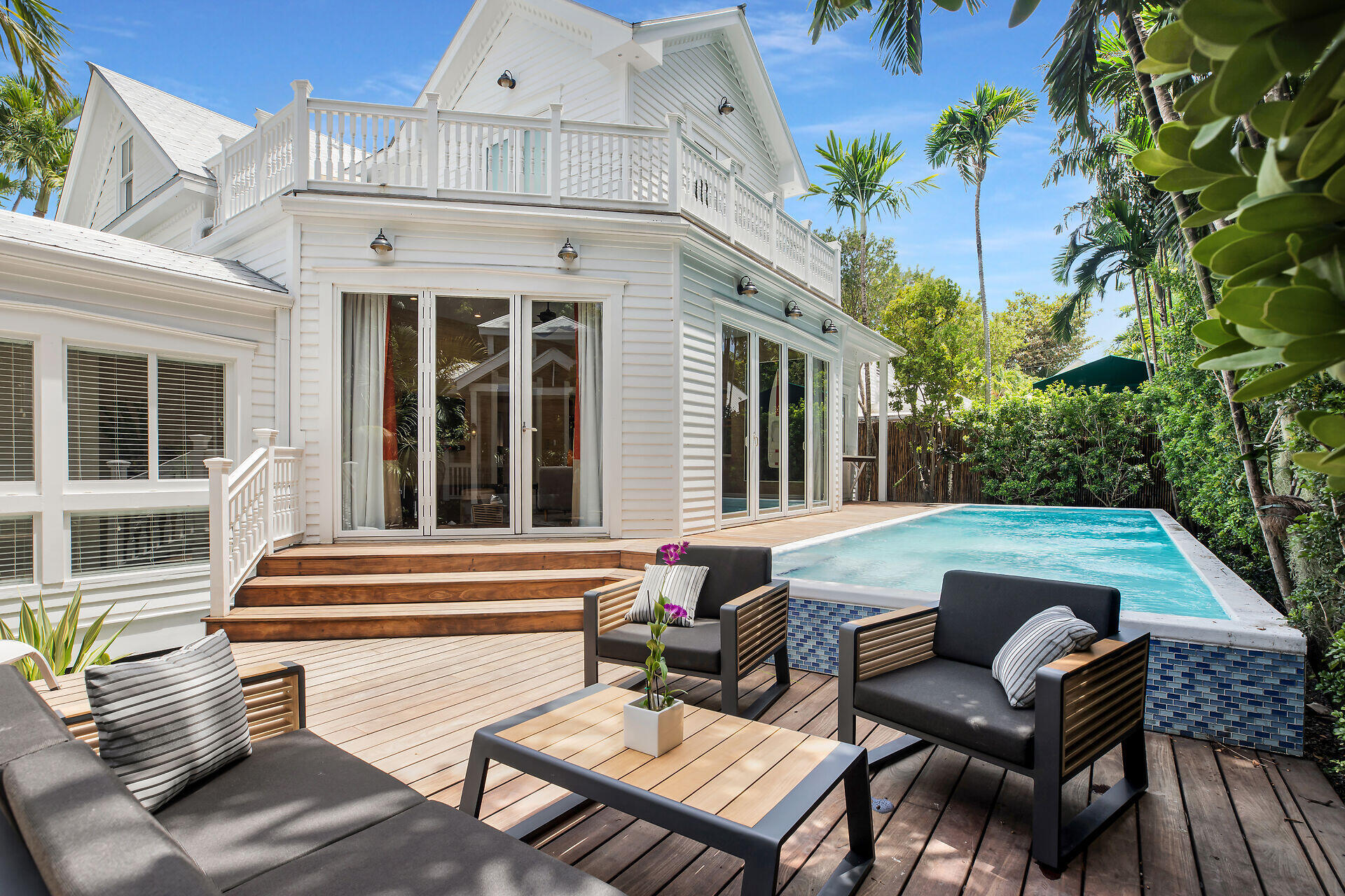 a view of a patio with couches table and chairs and potted plants