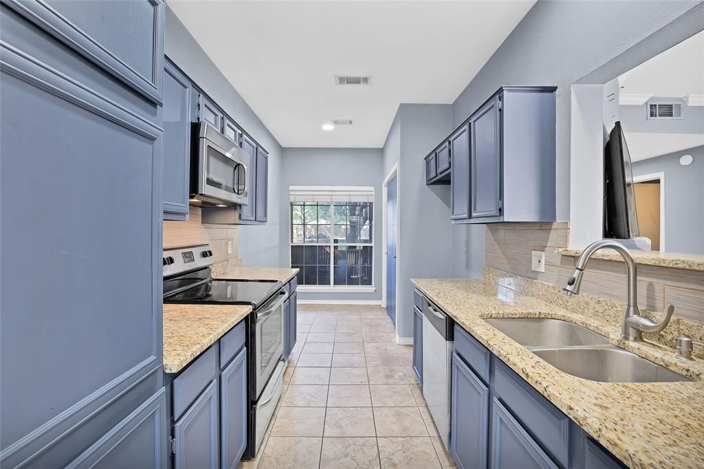 a kitchen with stainless steel appliances granite countertop a sink and cabinets