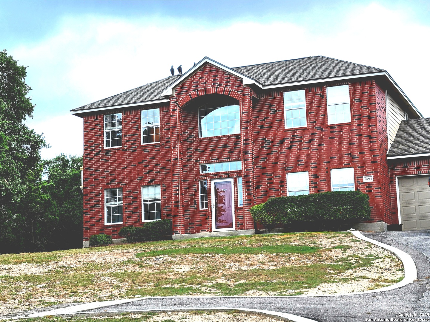 a view of a brick house with a yard