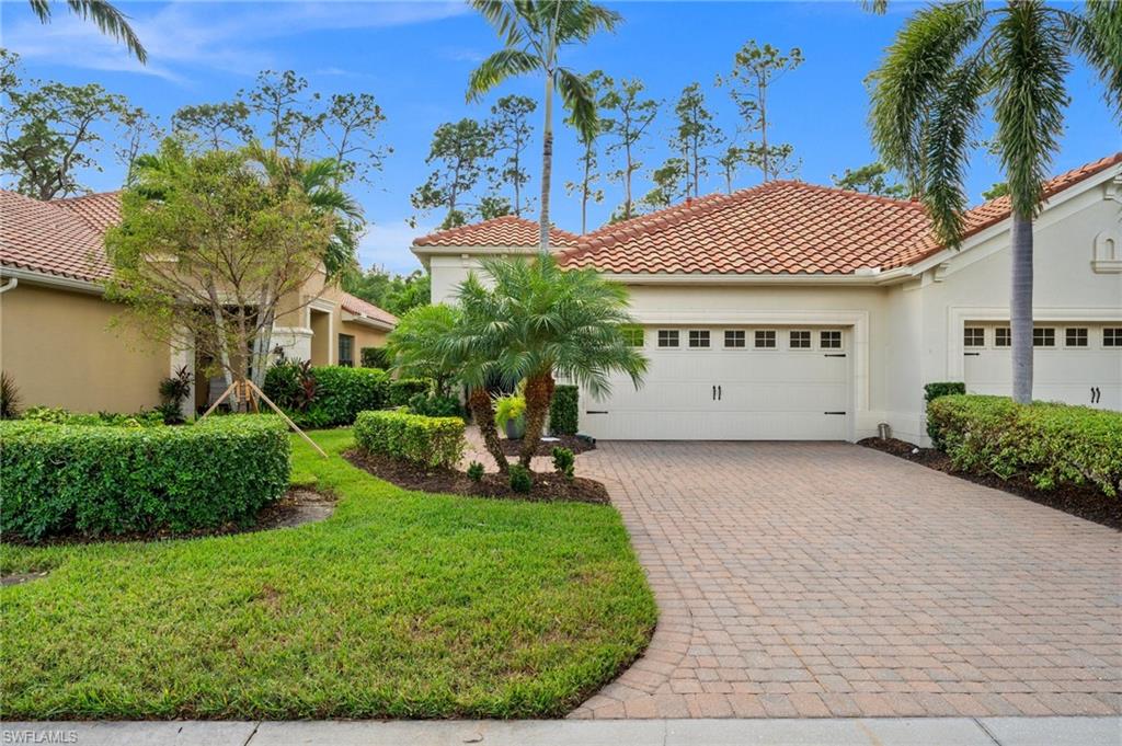 a view of a house with a yard and potted plants