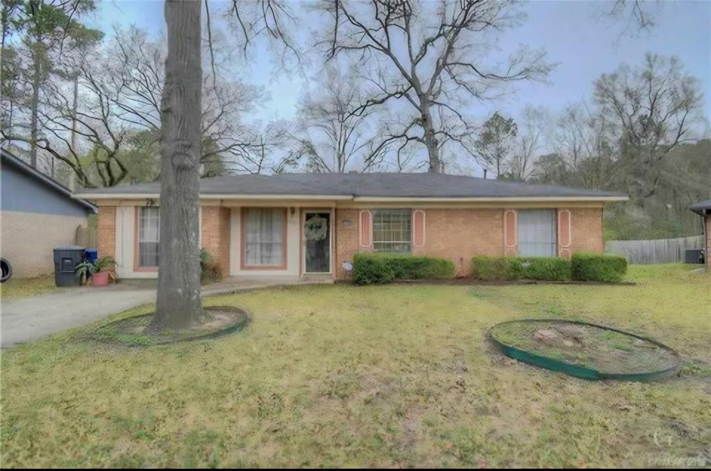 a view of a house with backyard and trees