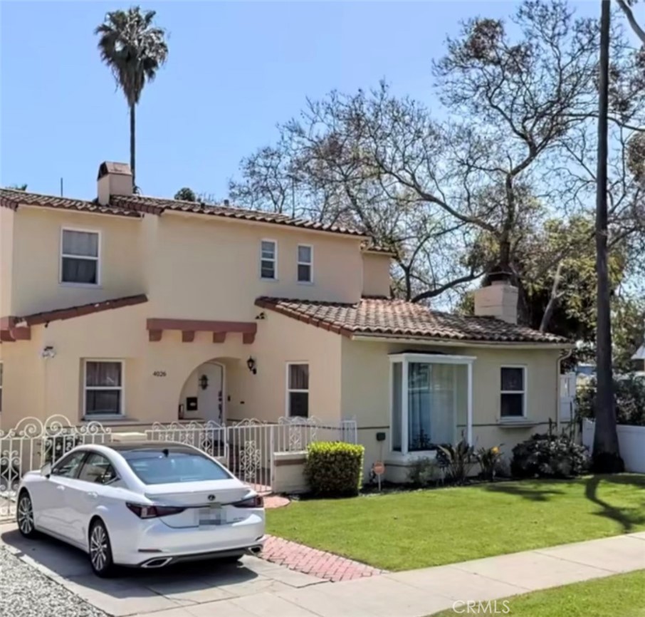 a front view of a house with a garden and plants