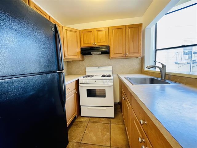 a kitchen with a sink a stove and a refrigerator