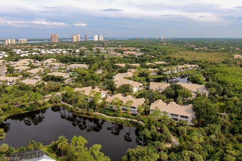 an aerial view of residential houses with outdoor space and trees