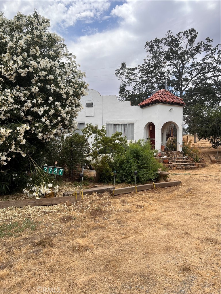 a white house that has a tree in front of it