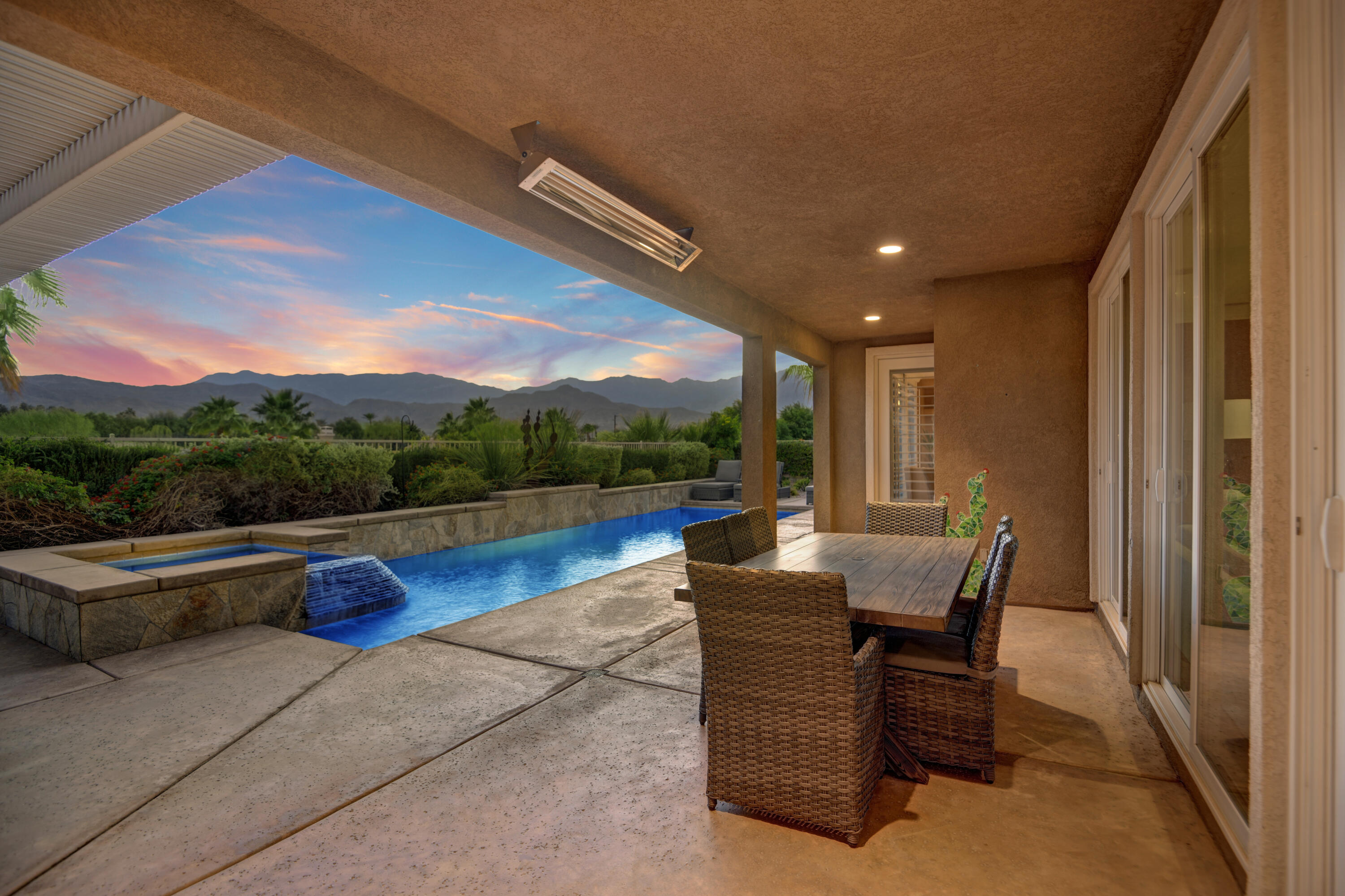 a view of swimming pool with a table and chairs in patio