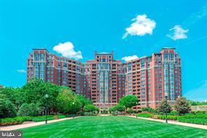 a view of a multi story building with yard and green space