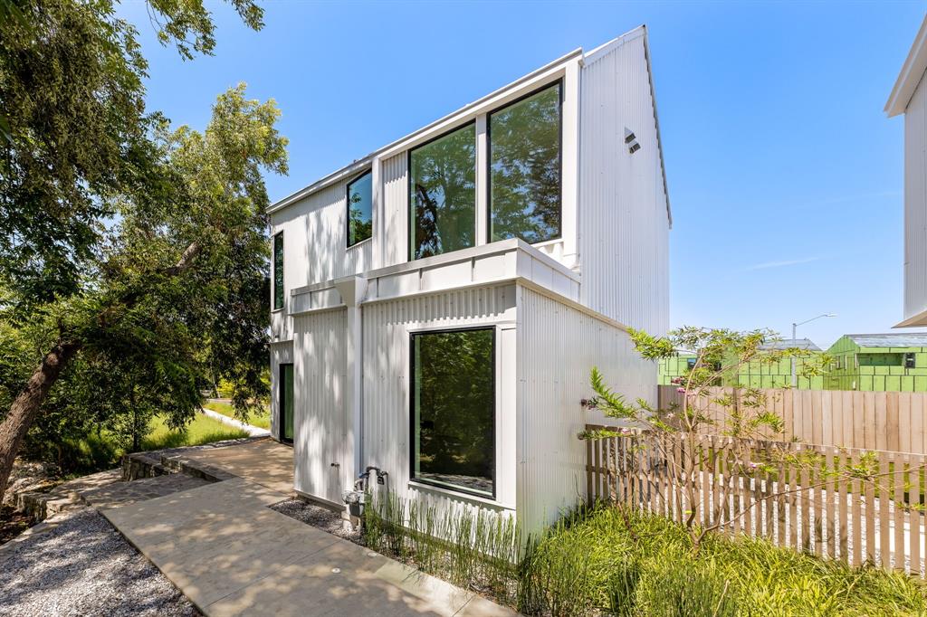 a view of a house with a small yard and floor to ceiling window