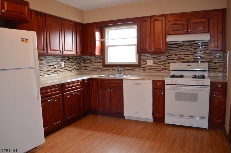 a kitchen with granite countertop wooden cabinets and white appliances