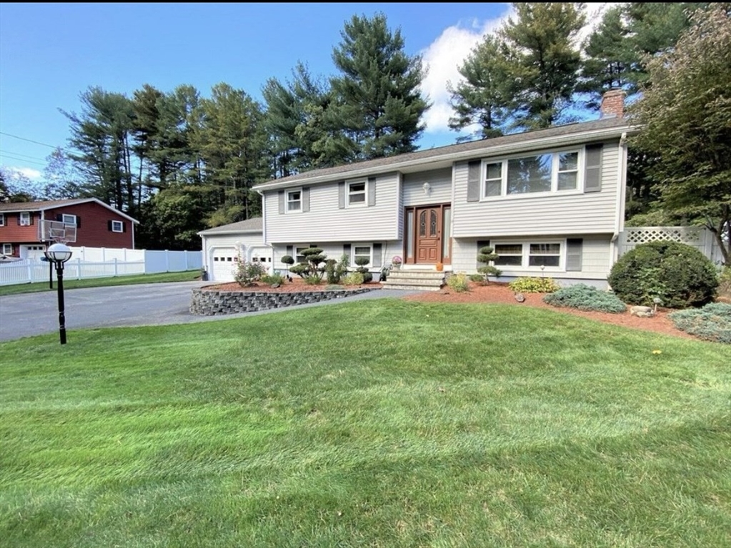 a view of a house with a yard and sitting area