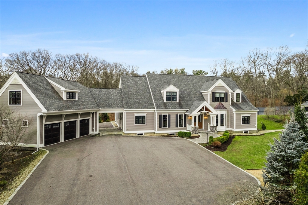 a front view of a house with a yard and lake view