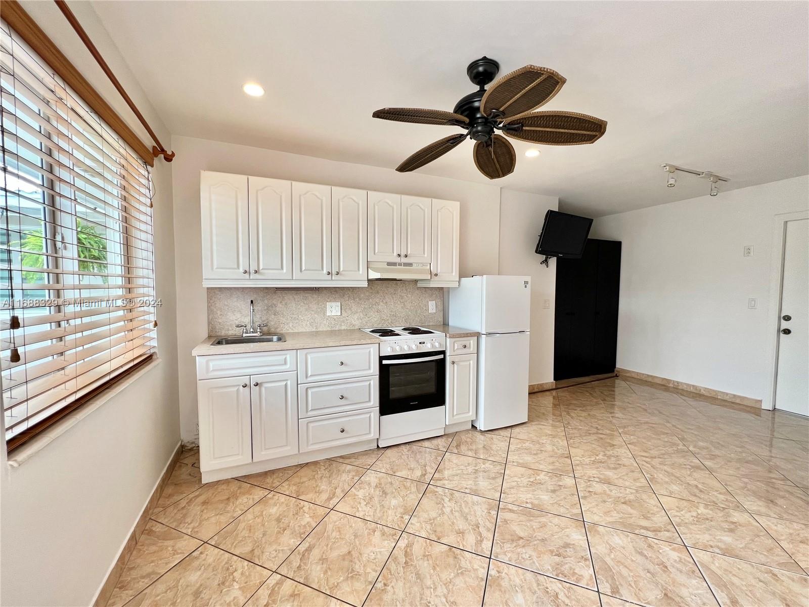 a kitchen with a stove cabinets and window