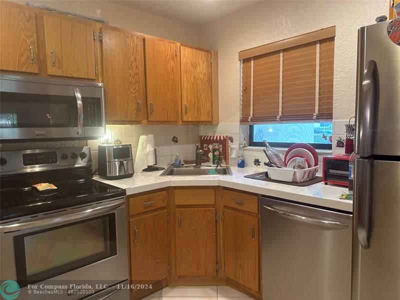 a kitchen with stainless steel appliances granite countertop a stove sink and cabinets