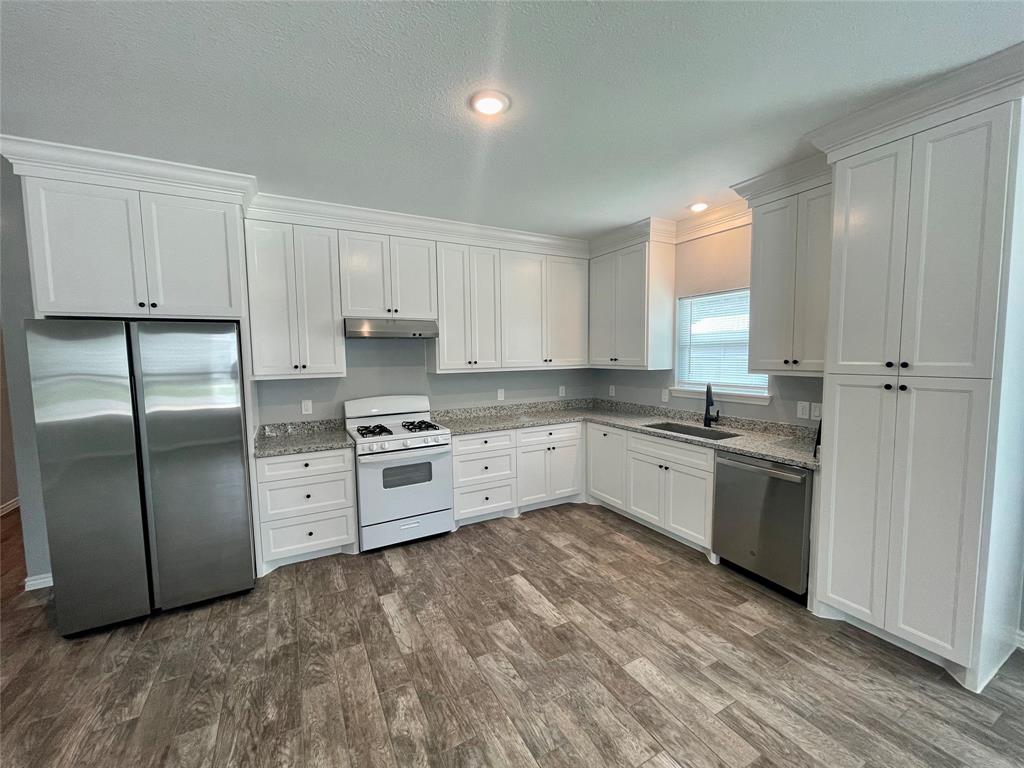 a kitchen with stainless steel appliances a refrigerator sink and cabinets