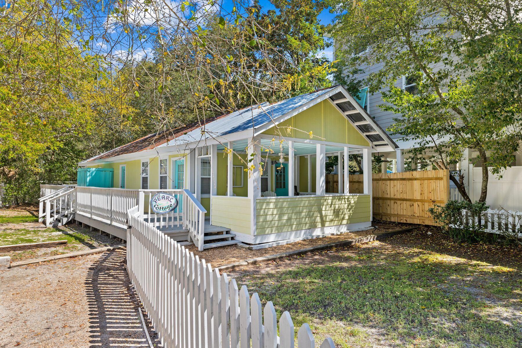 a view of a house with a small yard and wooden fence