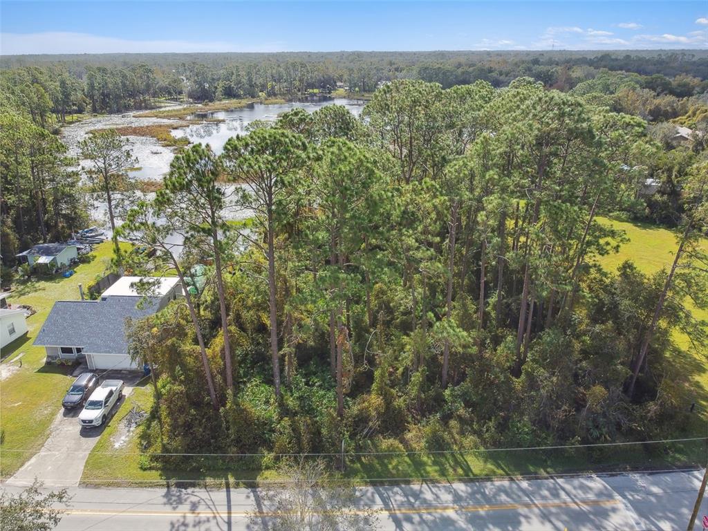 an aerial view of residential houses with outdoor space and trees