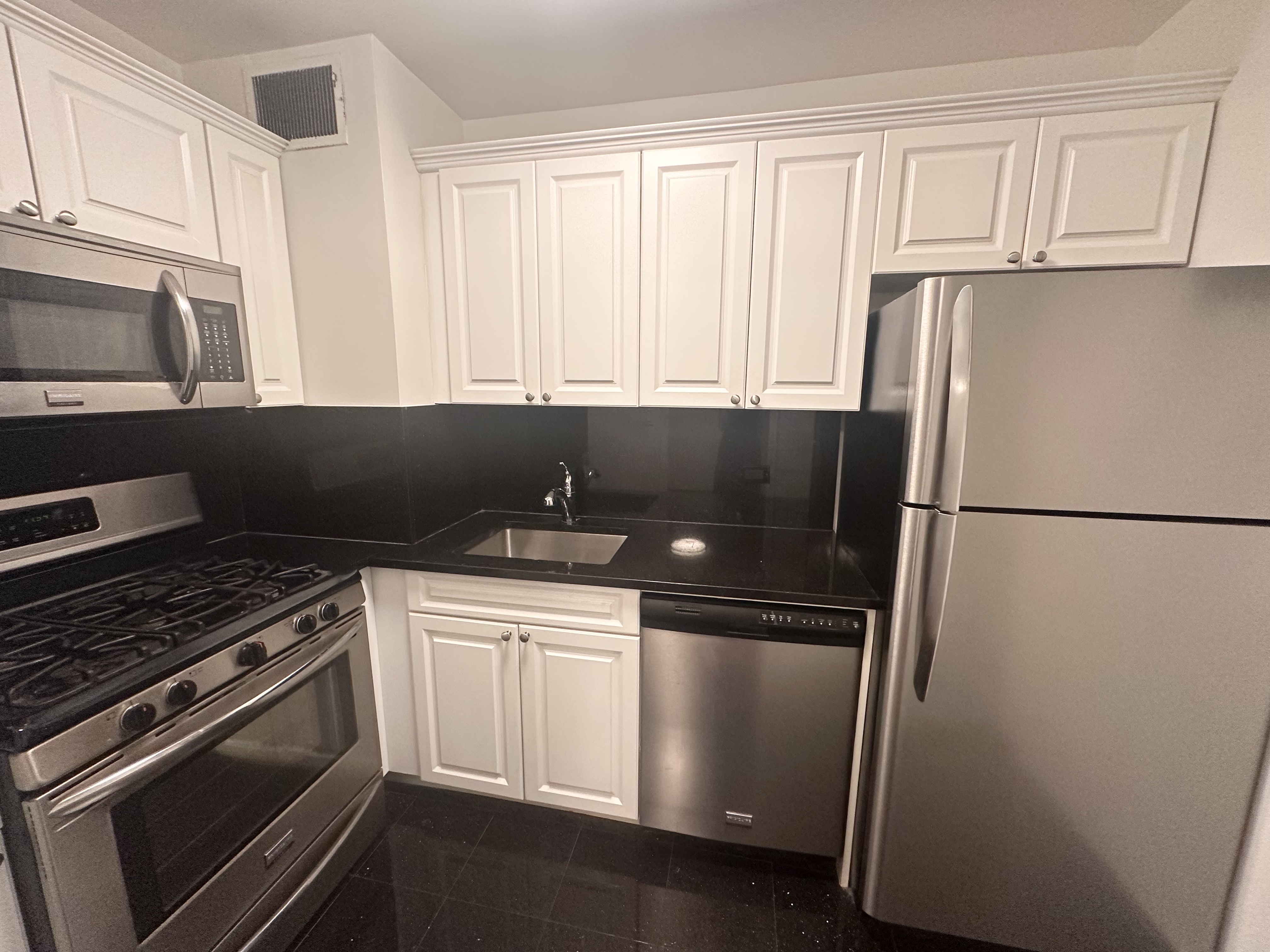 a kitchen with a refrigerator stove and cabinets