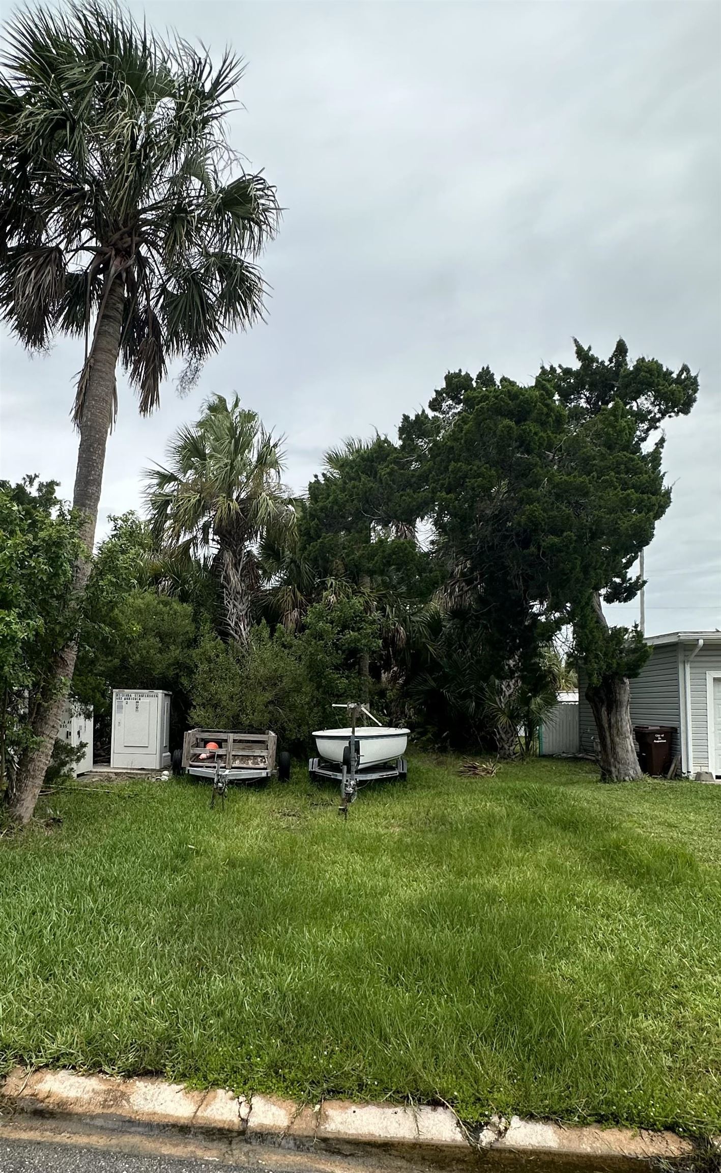 a front view of a house with a garden and trees