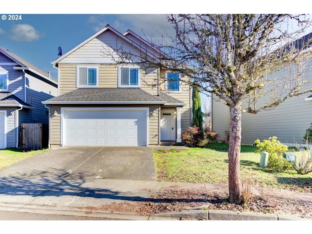 a view of a house with a yard and garage