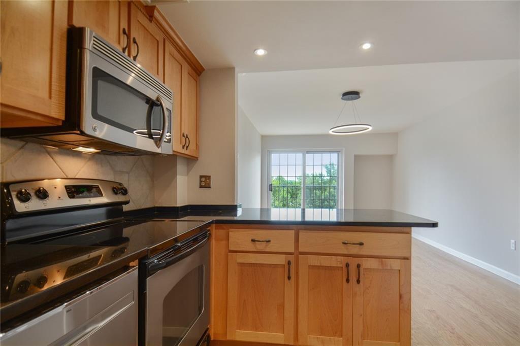 a kitchen with stainless steel appliances granite countertop a stove a sink and a microwave