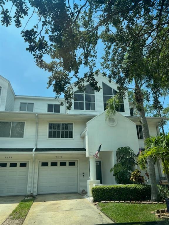 a view of a house with a yard garage and tree