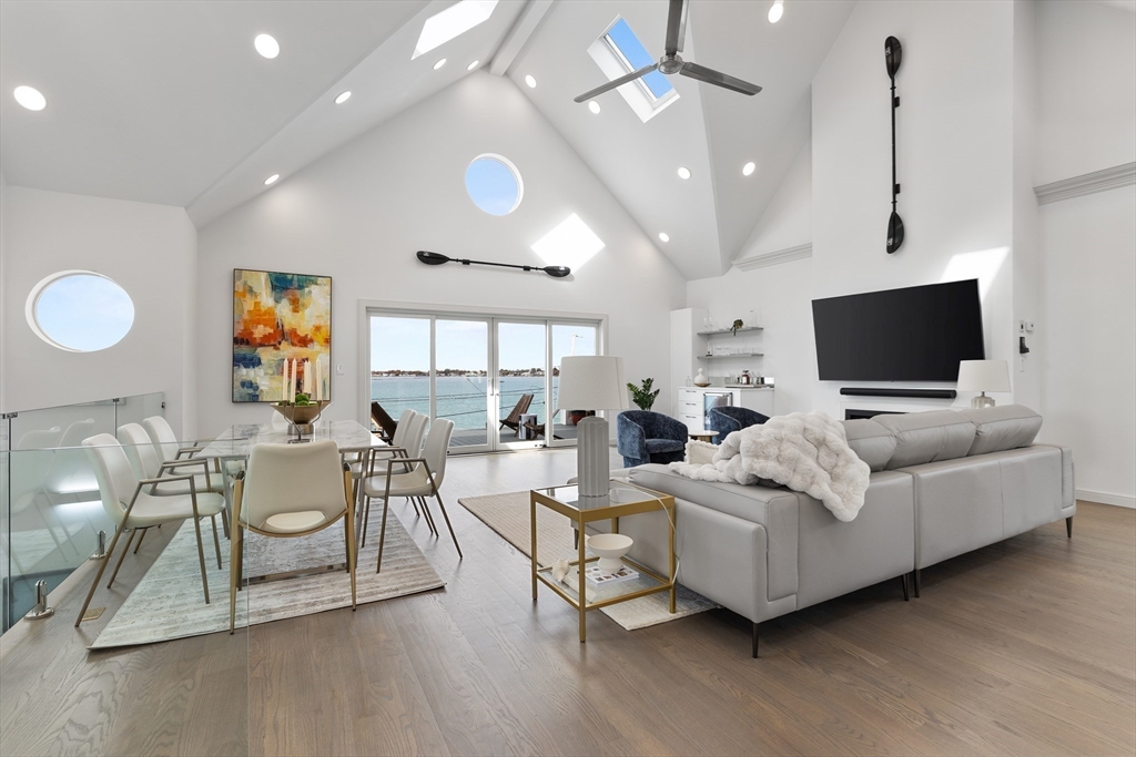 a living room with furniture a flat screen tv and kitchen view