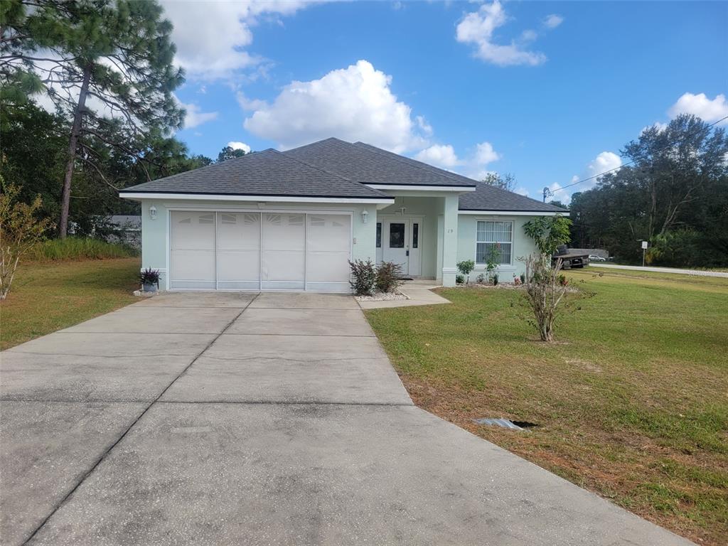 a front view of a house with a garden and yard