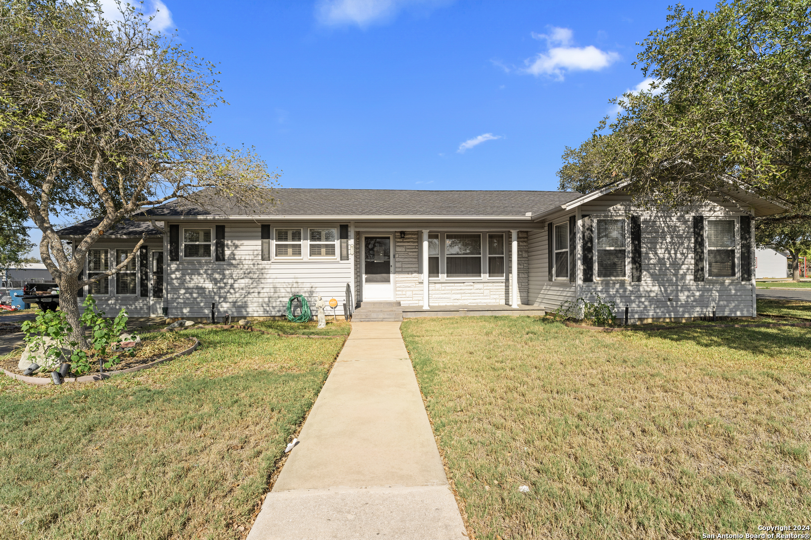 a front view of a house with a garden