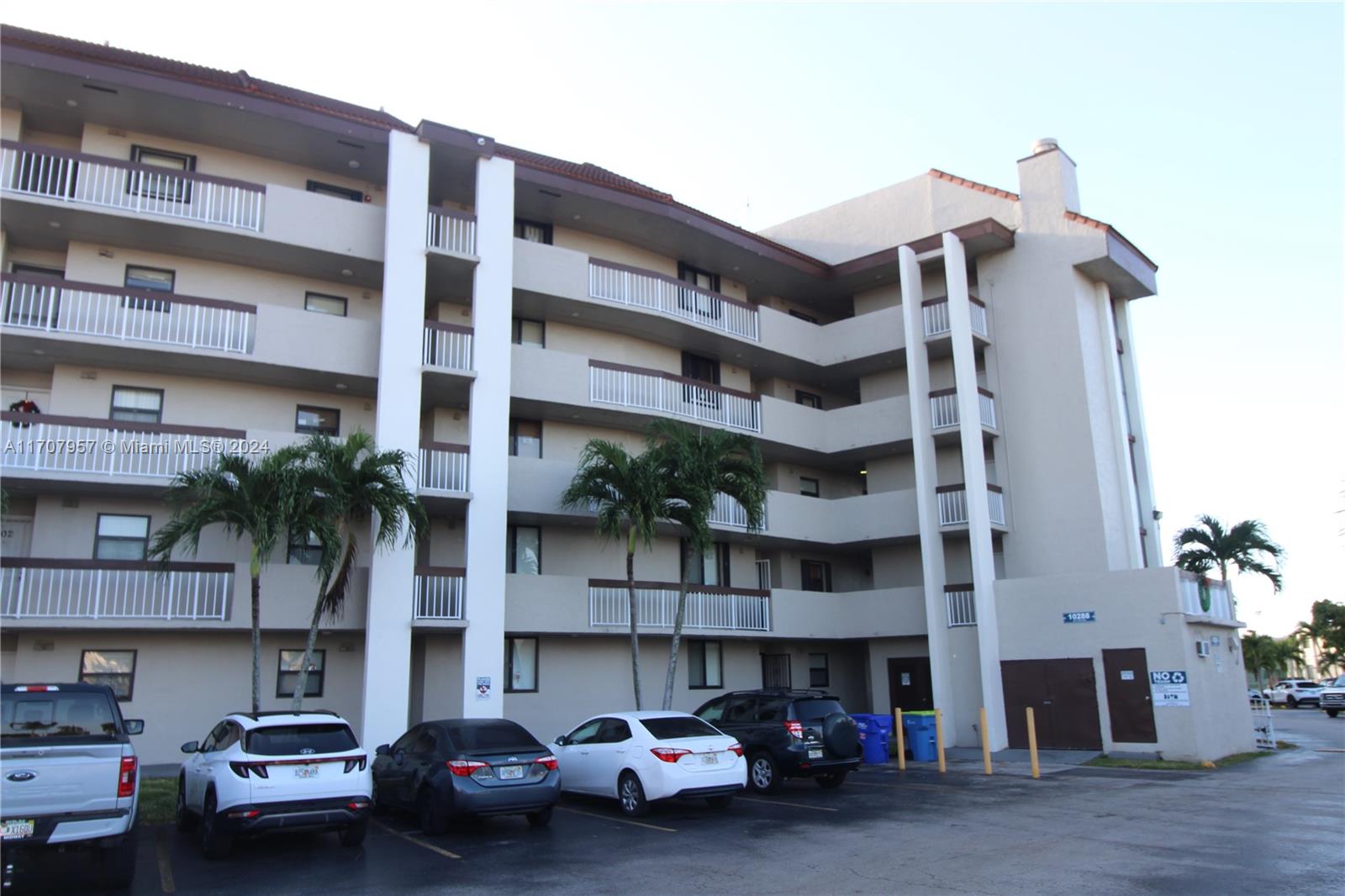 a view of building with cars parked in front of it