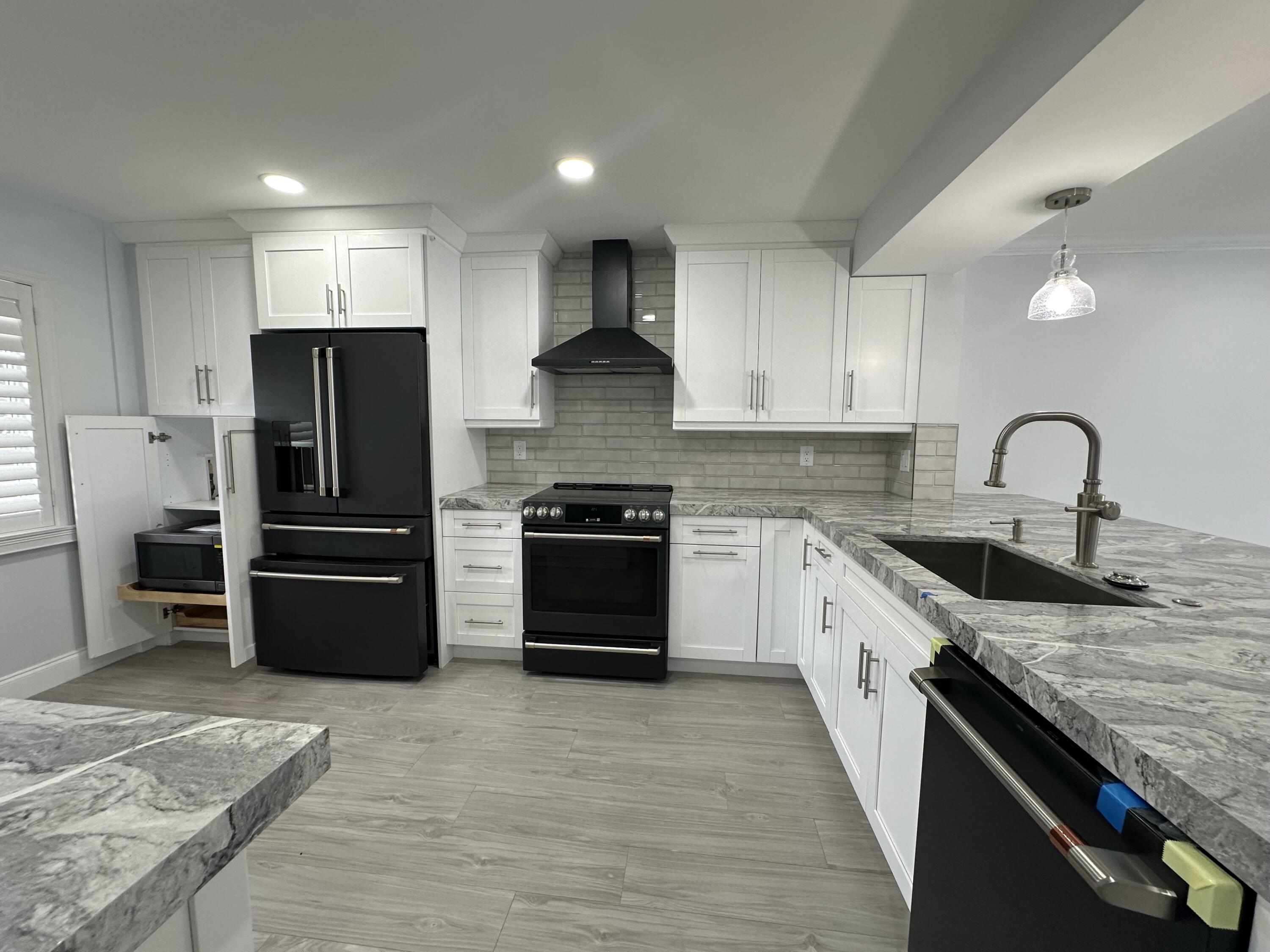 a kitchen with stainless steel appliances granite countertop a refrigerator stove and sink