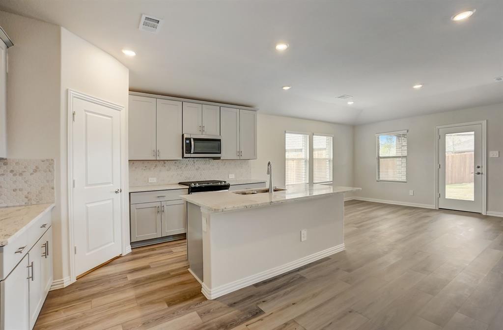 a kitchen with granite countertop white cabinets and white appliances