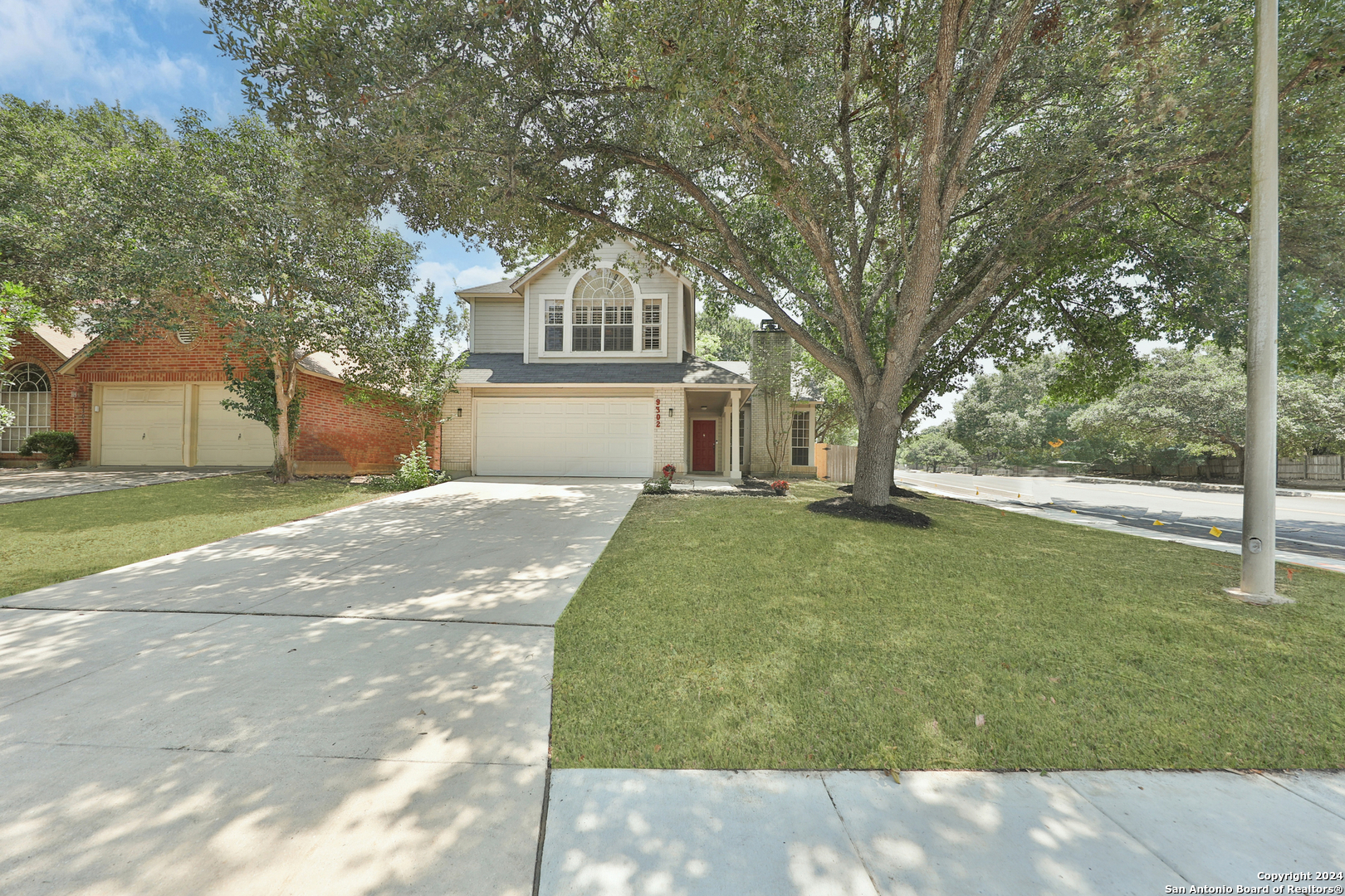 a front view of a house with a yard and trees