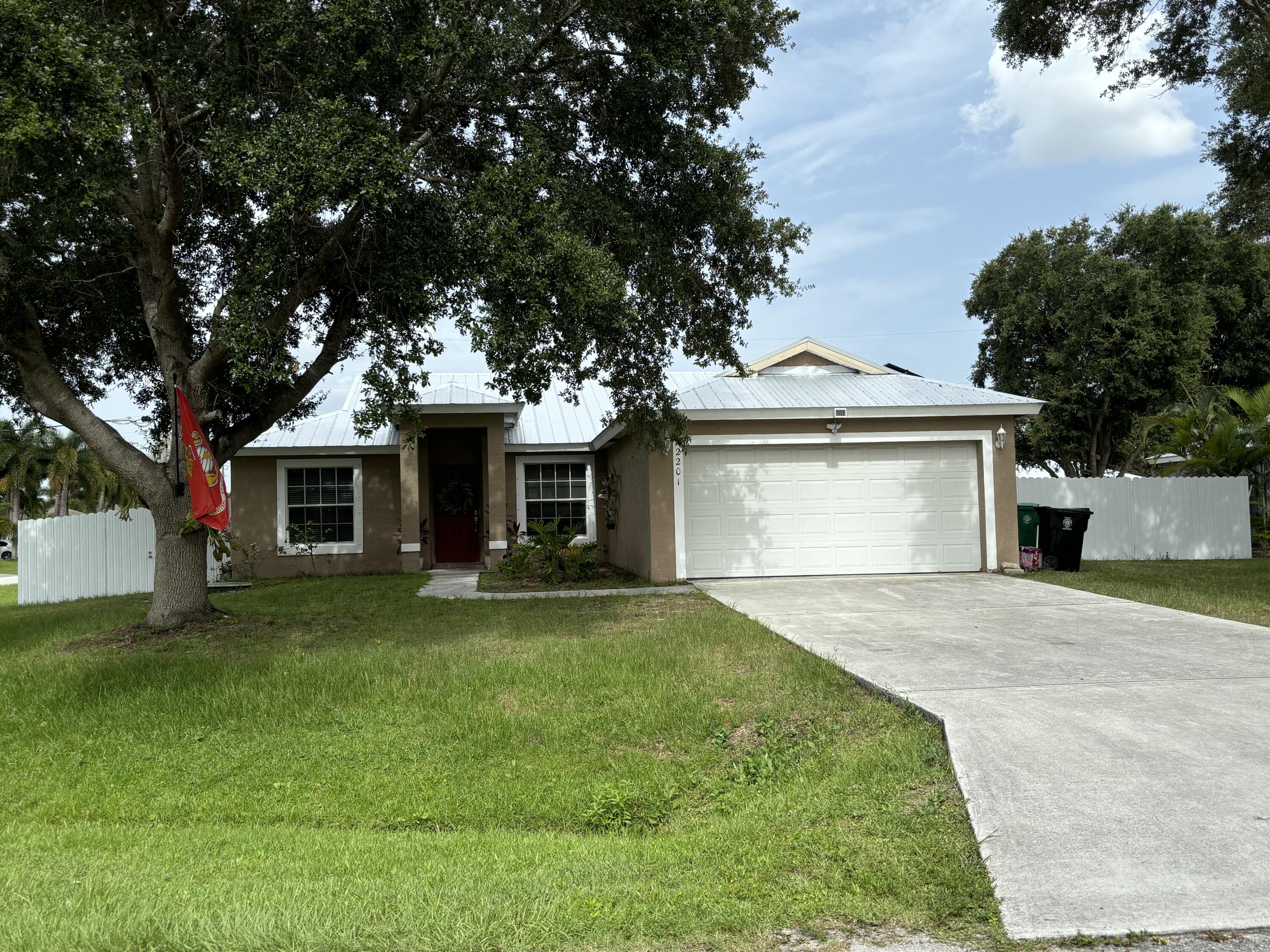 a front view of a house with a garden and trees