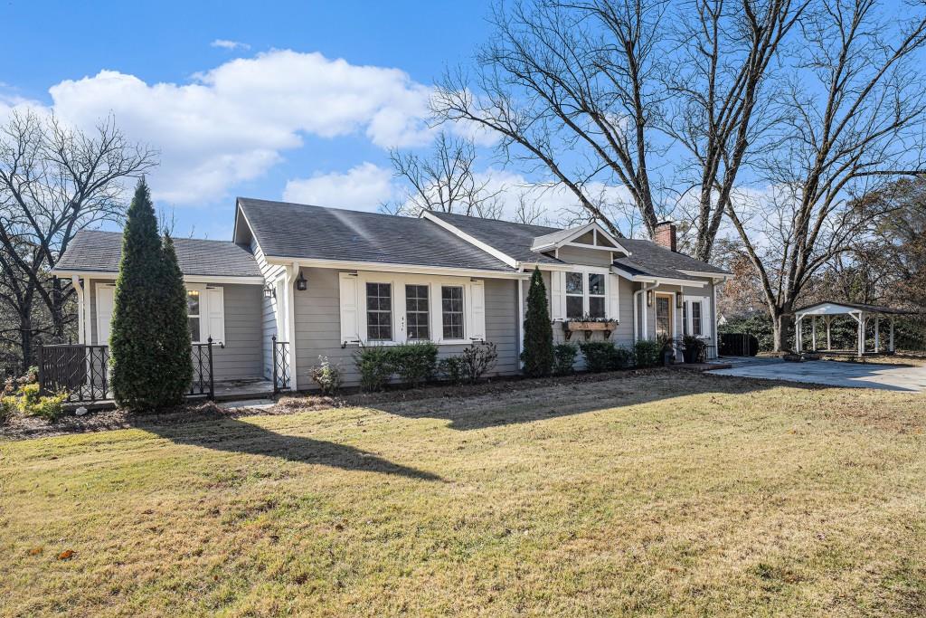 a front view of house with yard and trees around