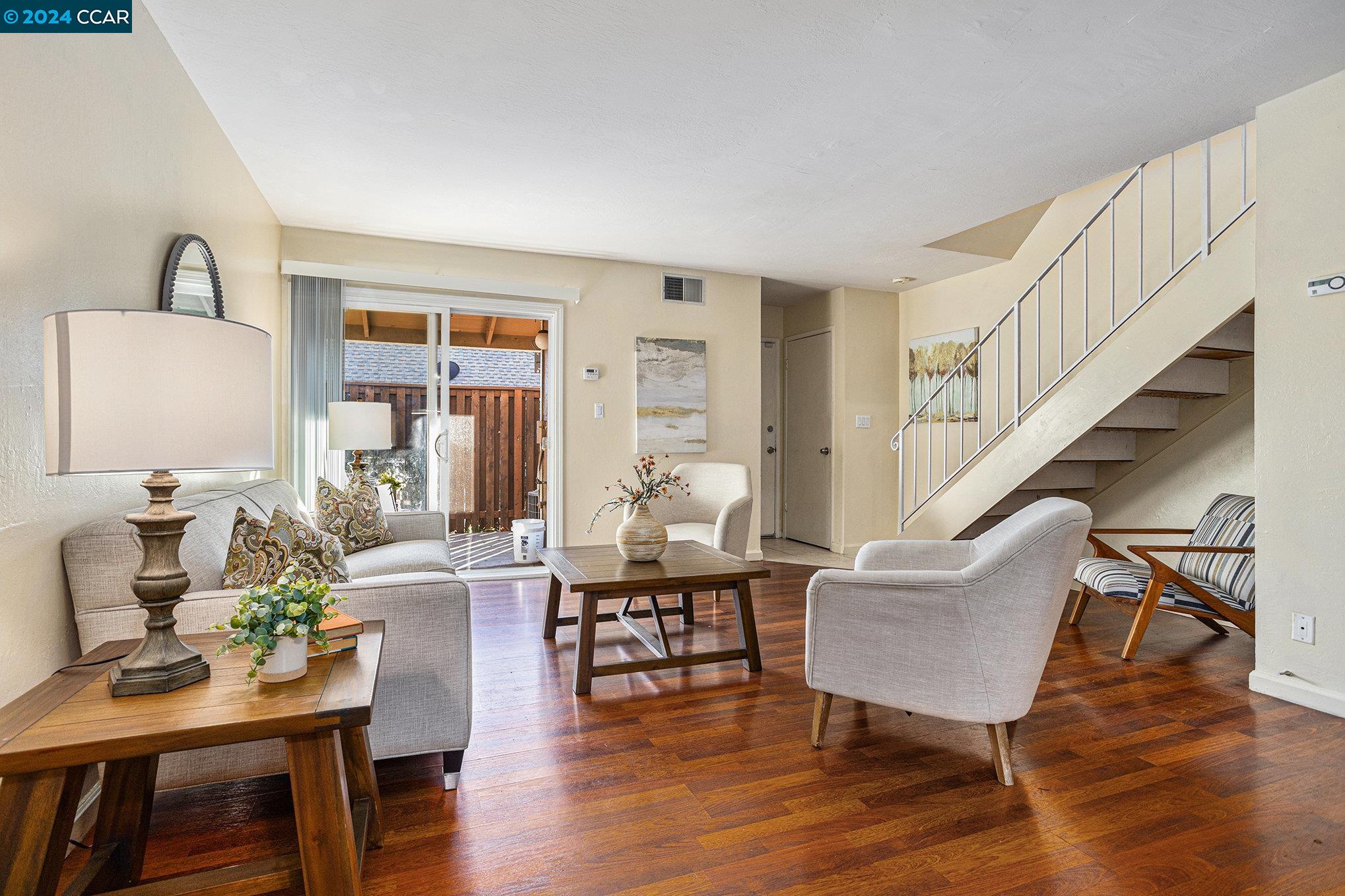 a living room with furniture and wooden floor