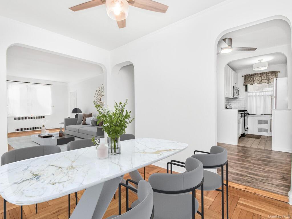 Dining room featuring ceiling fan, hardwood / wood-style floors, and radiator heating unit