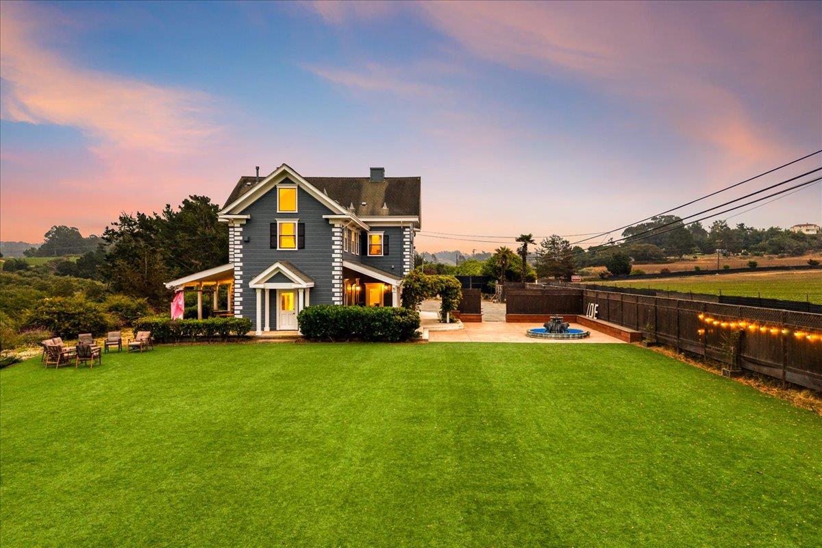 a front view of a house with garden and trees