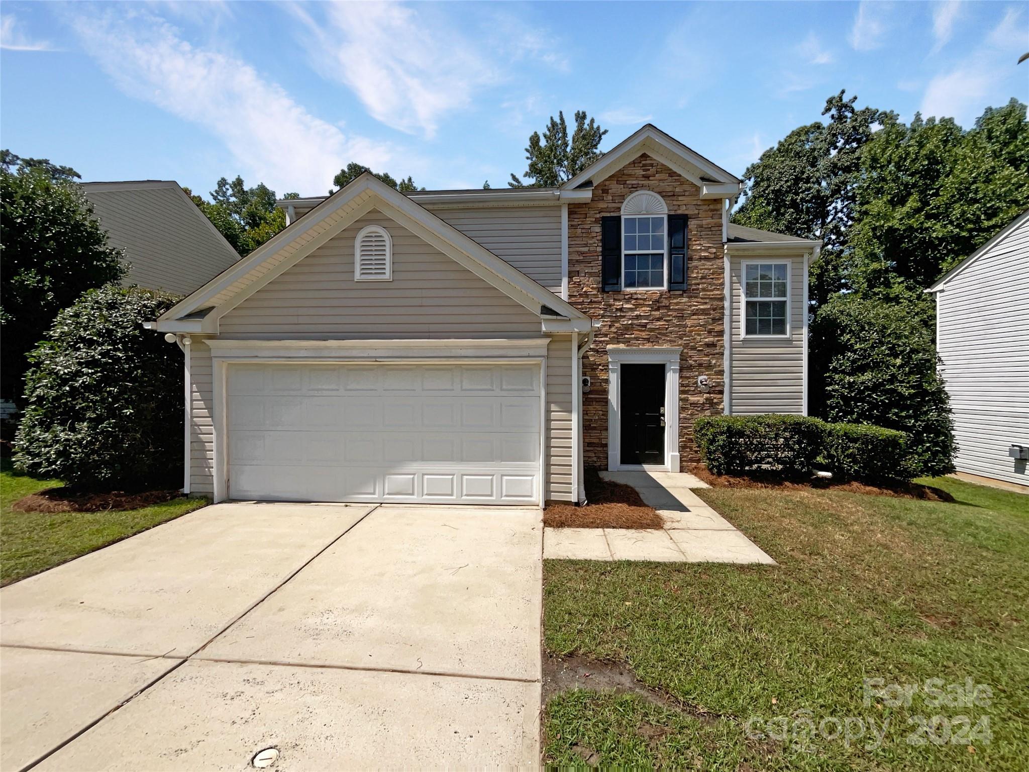 a front view of a house with a yard and garage