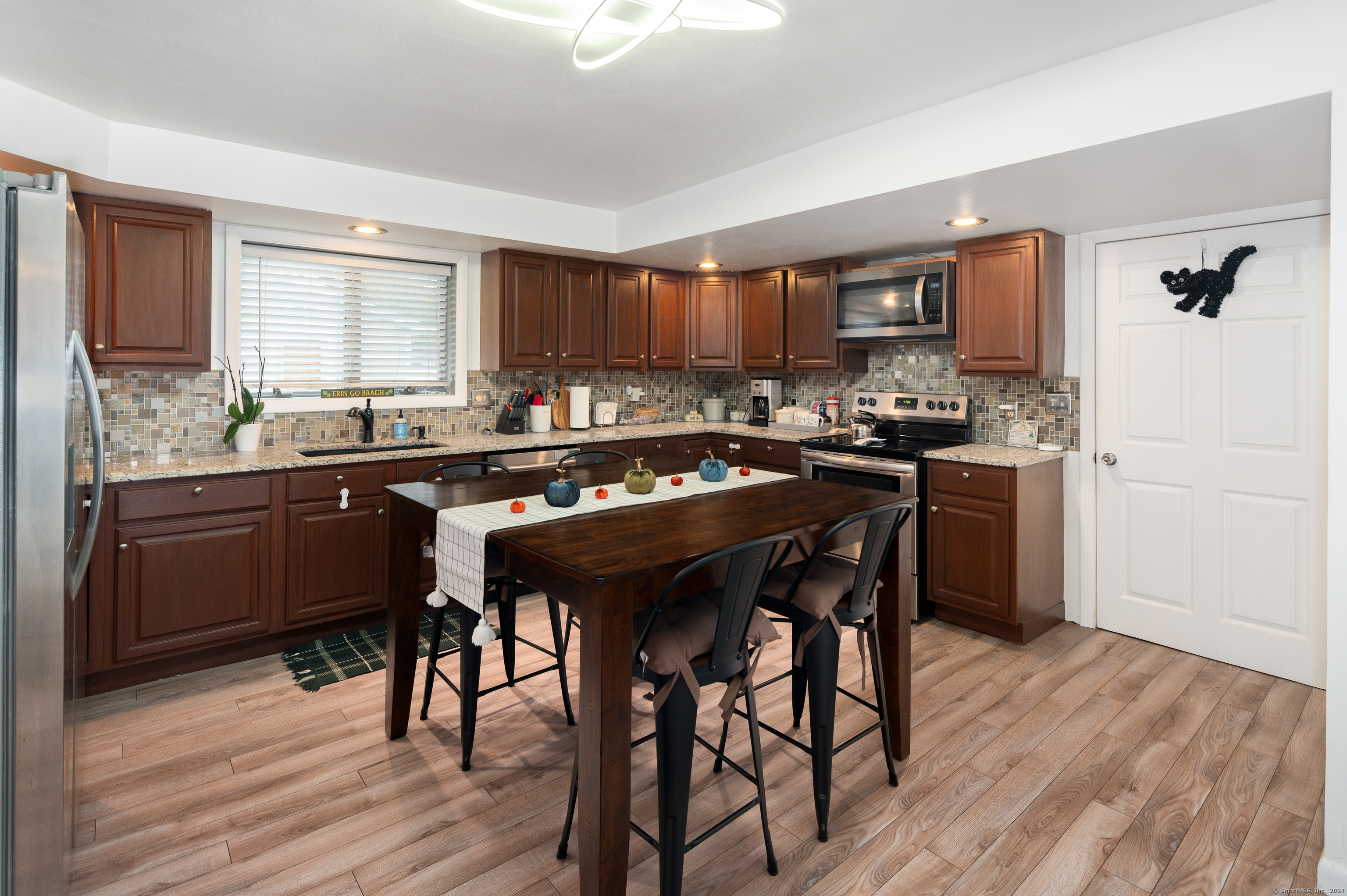 a kitchen with a sink a stove a refrigerator and wooden cabinets