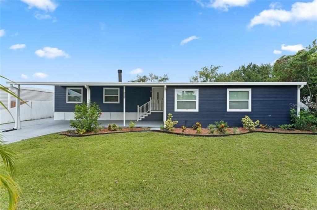 a view of an house with backyard and porch