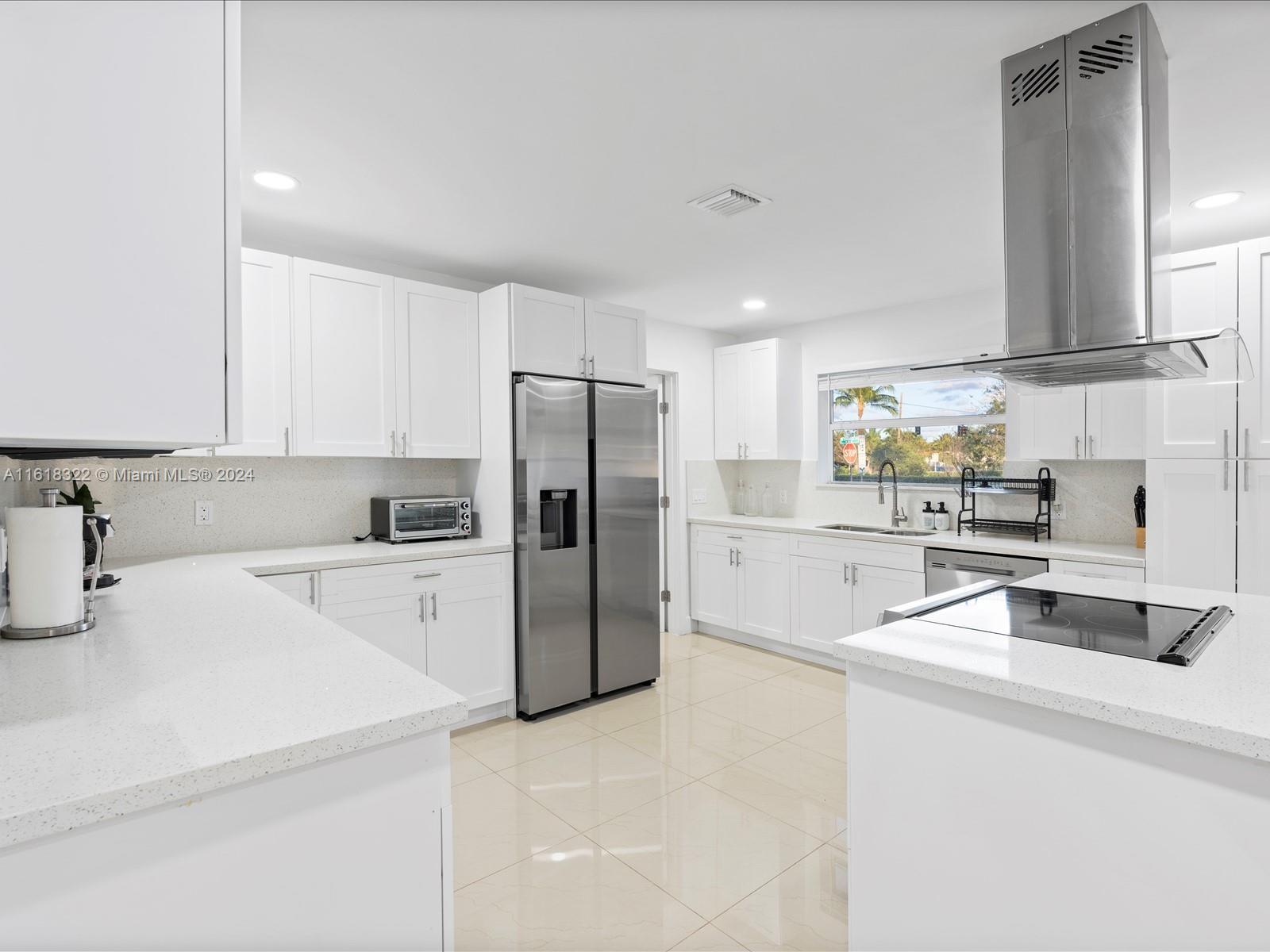 a kitchen with stainless steel appliances a refrigerator sink and white cabinets