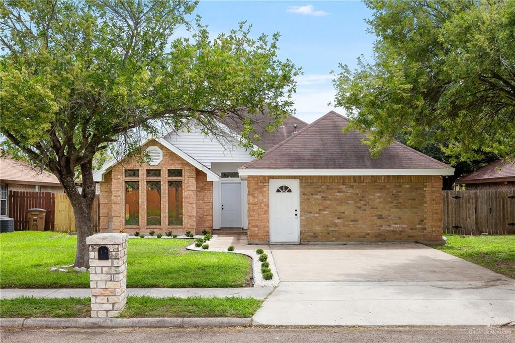 View of front of house with central AC unit and a front yard