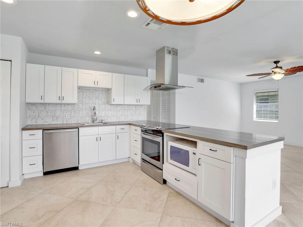 a kitchen with granite countertop white cabinets and white appliances