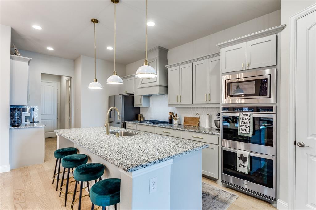 a kitchen with granite countertop kitchen island stainless steel appliances a stove sink microwave and cabinets