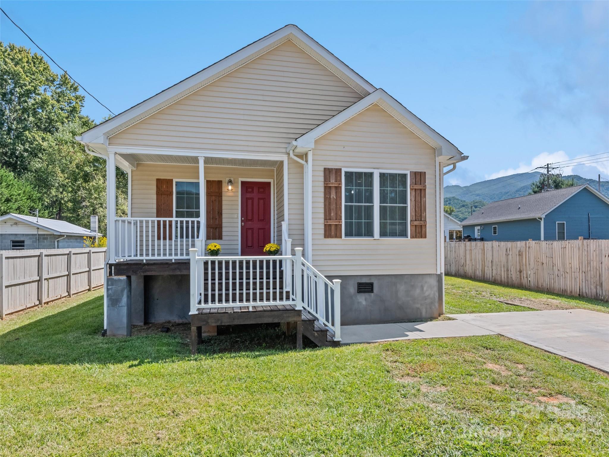 a front view of a house with a yard and deck