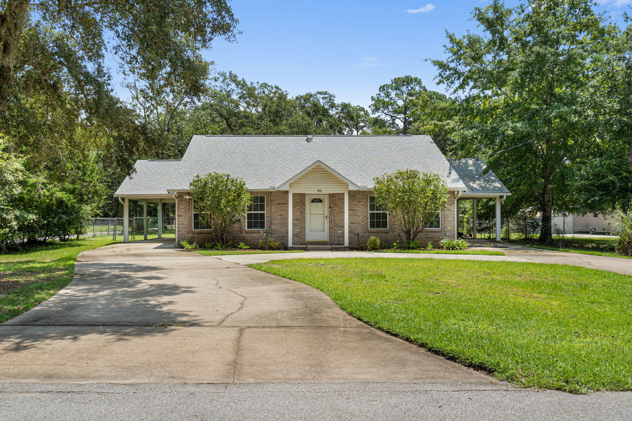 a front view of a house with a garden and trees