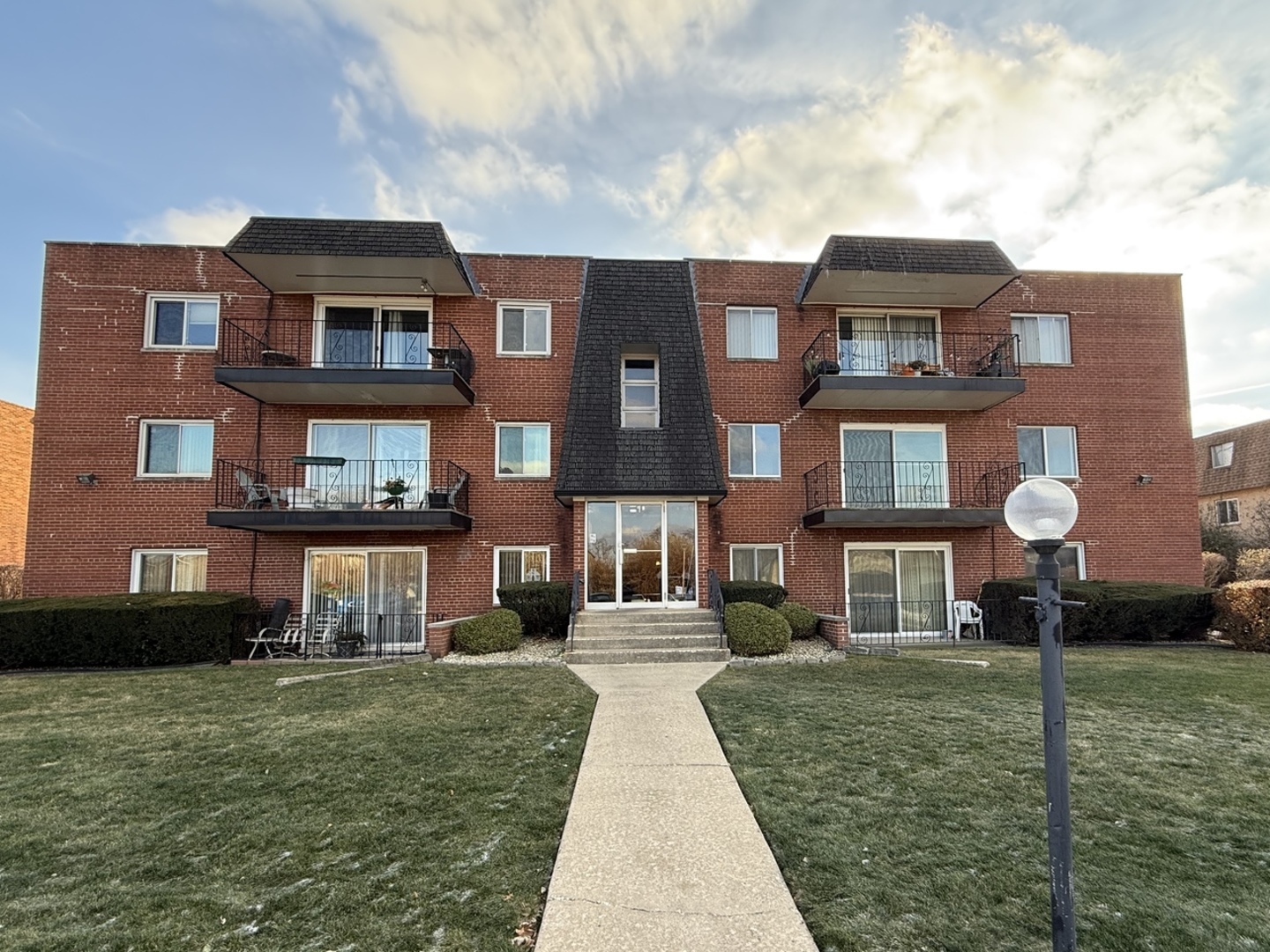 a front view of a residential apartment building with a yard