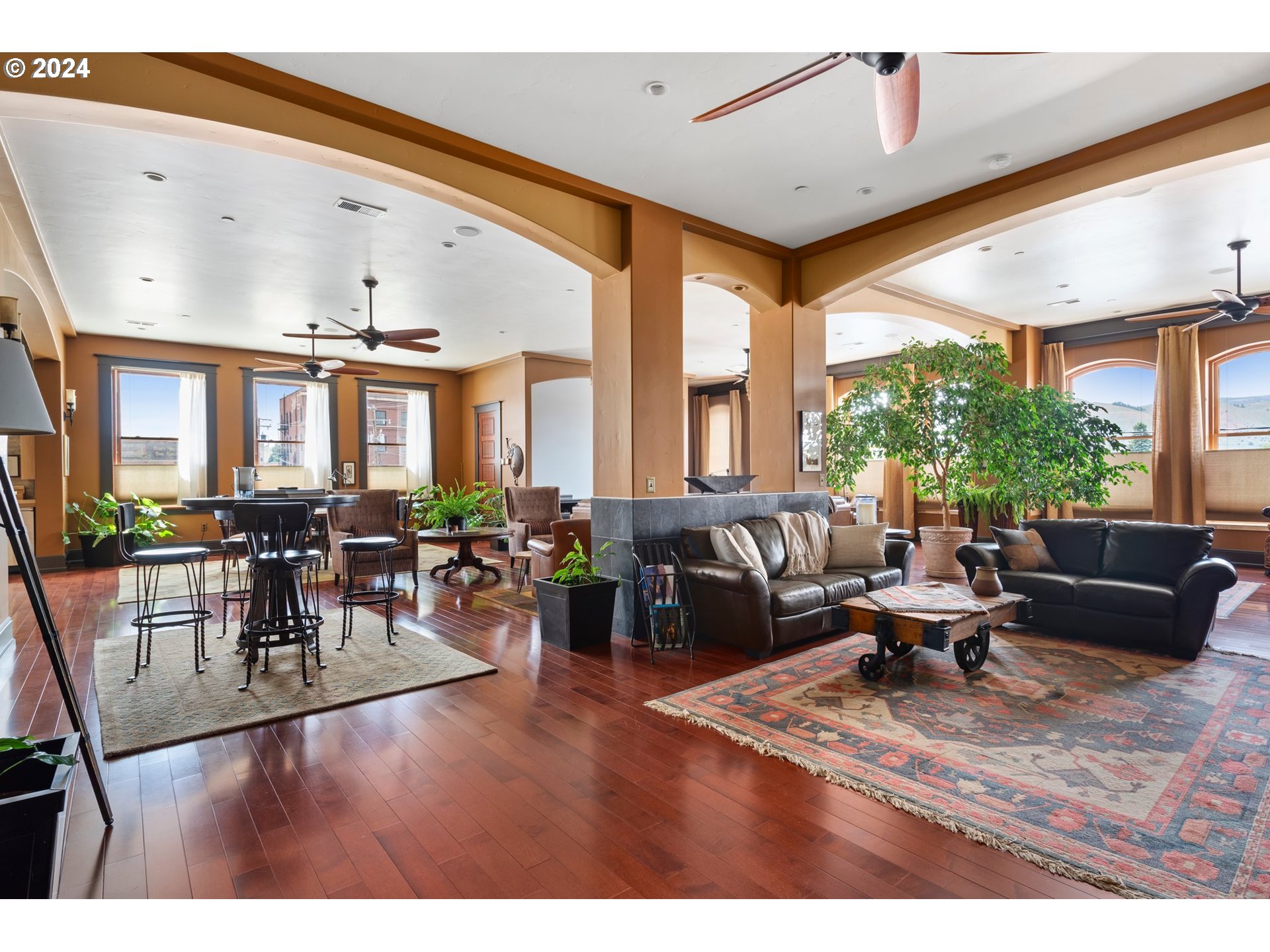 a living room with furniture wooden floor and a large window